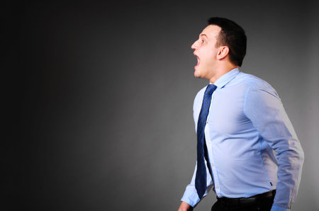 businessman is screaming on dark backgroundの写真素材