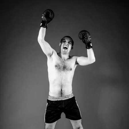 mma fighter with hands up on gray backgroundの写真素材