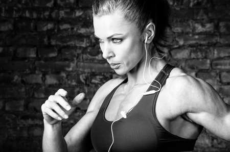 strong woman is running and listening musicの写真素材
