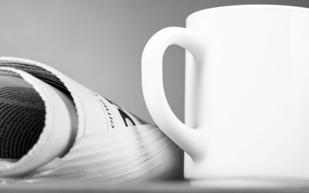 close-up view of white cup and folded newspaper
