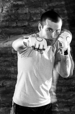 portrait of mma fighter in boxing pose against brick wallの写真素材