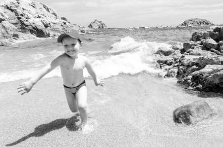 young boy is playing on a sea coastの写真素材