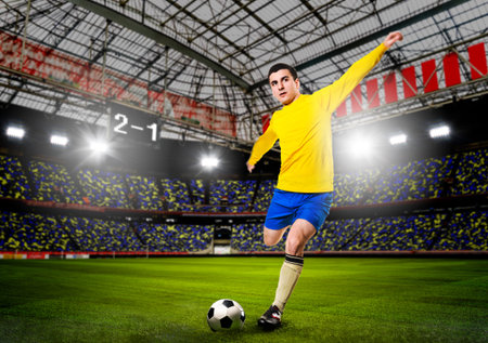 soccer or football player is kicking ball on stadiumの写真素材