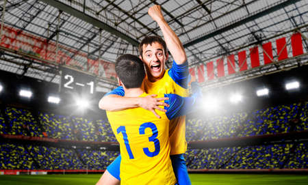 soccer or football players are celebrating goal on stadiumの写真素材