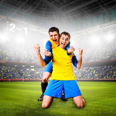 soccer or football players are celebrating goal on stadiumの写真素材