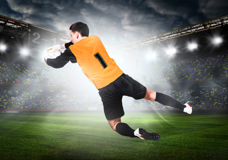 soccer or football goalkeeper is catching ball on stadium