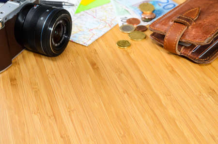 getting ready for travel, money, map and photo camera on wooden table with copy spaceの写真素材