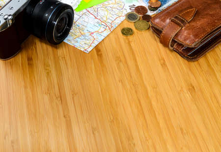 getting ready for travel, money, map and photo camera on wooden table with copy spaceの写真素材