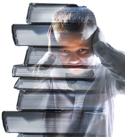 unhappy tired school boy mixed with pile of books, isolated on white backgroundの写真素材