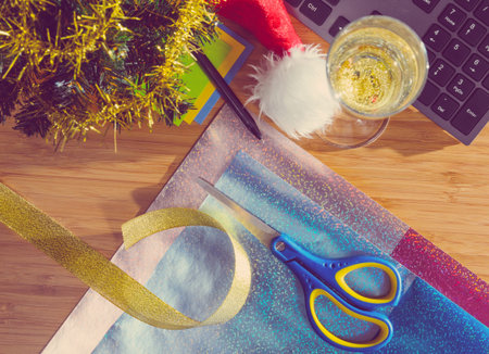 office desk with christmas accessories, wrapping paper for presents and stationery, view from aboveの写真素材