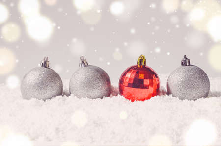 silver and red decorative christmas balls on snow against grey festive backgroundの写真素材