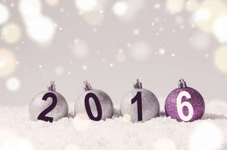 2016 year. Silver and purple decorative christmas balls on snow against grey festive backgroundの写真素材
