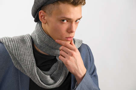 Portrait of a young artist wearing scarf and cap, against gray backgroundの写真素材