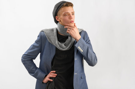 Portrait of a young artist wearing scarf and cap, against gray backgroundの写真素材