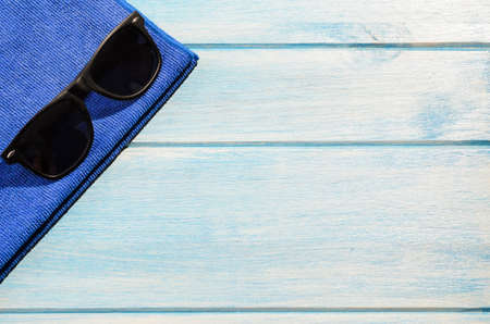 beach accessories. stylish sunglasses with towel on blue wooden tableの写真素材