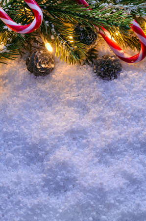Christmas fir tree with lights and candy cane on snow in dark, view from aboveの写真素材