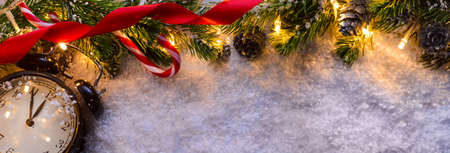 Christmas fir tree with lights and clock on snow in dark, view from aboveの写真素材