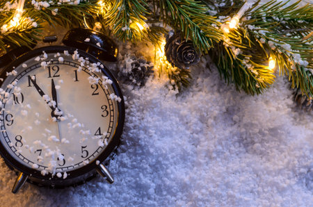 Christmas fir tree with lights and clock on snow in dark, view from aboveの写真素材