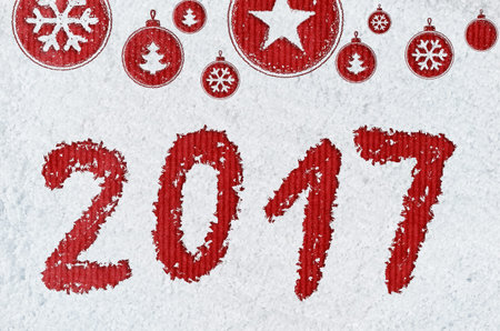 christmas card or new year background made of xmas symbols handwritten on snow and red craft paper