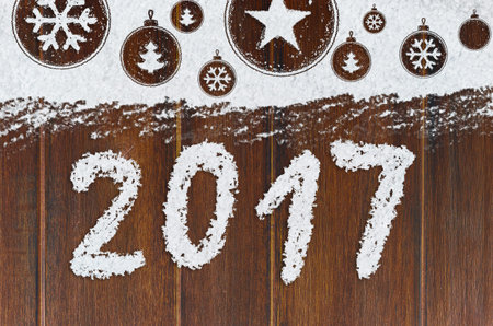 christmas card or new year background made of xmas symbols handwritten on snow and wooden table
