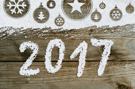 christmas card or new year background made of xmas symbols handwritten on snow and wooden tableの写真素材