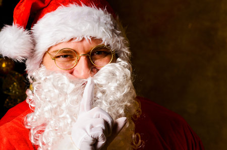Santa Claus with finger on lips asking for silence