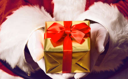 Santa Claus holding gift box in both handsの写真素材
