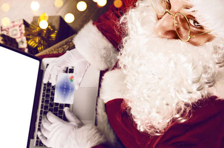 Santa Claus working with modern laptop on his lap, view from aboveの写真素材