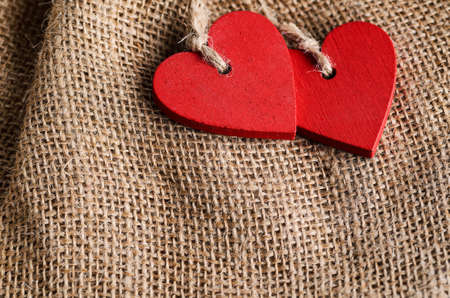 Couple of decorative wooden red hearts for Valentines day on canvas backgroundの写真素材