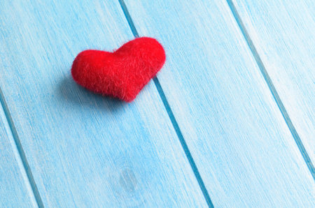 Red heart on blue wooden table