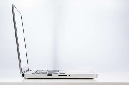 Modern laptop computer on abstract business background, side viewの写真素材