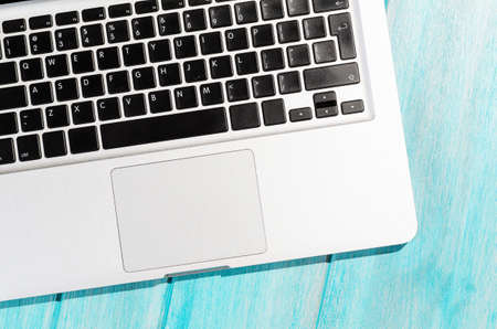 Modern laptop computer on blue table, view from aboveの写真素材