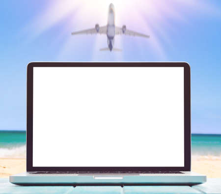 Modern laptop on blue wooden table with blank screen at tropical beachの写真素材
