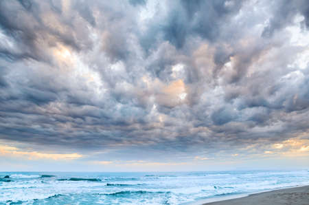 Dramatic cloudy sunset at seasideの写真素材