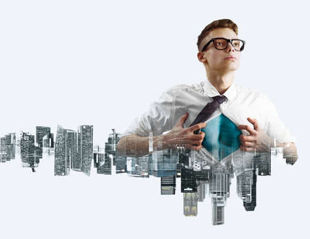 Business superhero double exposure concept. Young businessman showing super hero suit under his shirtの写真素材