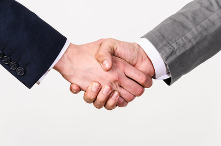 Two businessmen handshaking on gray background
