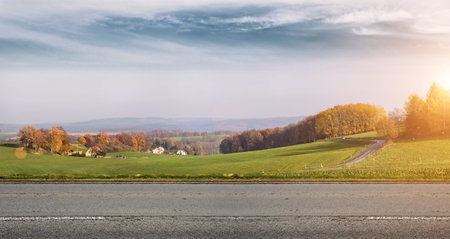 Autumn rural road with beautiful landscape behind it.の写真素材