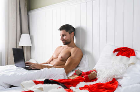 Santa Claus in hotel room without costume shopping for Christmas or New Yearの写真素材