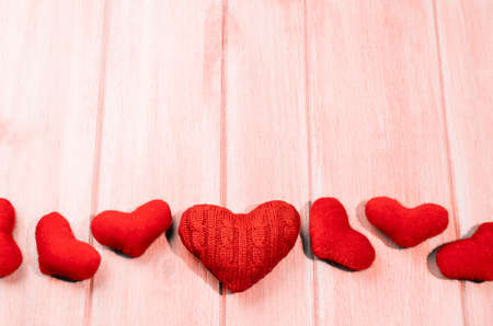 Set of glossy and craft red hearts for Valentines day on living coral colored wooden tableの写真素材