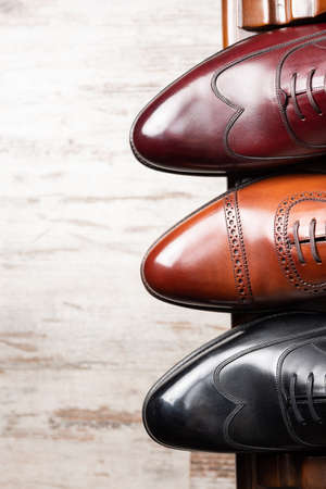 Black and brown full grain leather shoes on wooden display in in men shoes boutique store.の写真素材