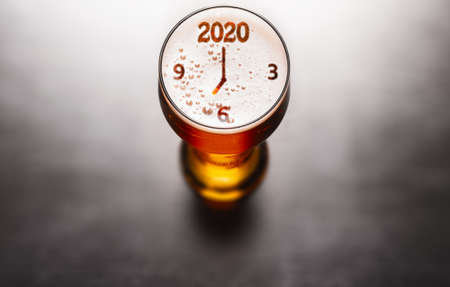 New Year beer. 2020 symbol on beer glass foam on black table, view from above