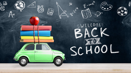 Back to school. Car delivering books and apple against school blackboard with education symbols.