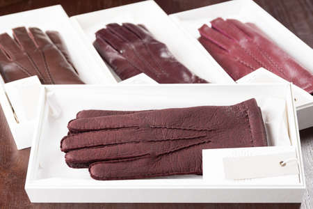 Burgundy leather gloves in boxes at luxury clothing boutique store.の写真素材