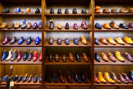 Full grain leather shoes on wooden display in men shoes boutique store. Black, brown and other colors.の写真素材