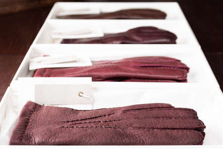 Burgundy leather gloves in boxes at luxury clothing boutique store.の写真素材