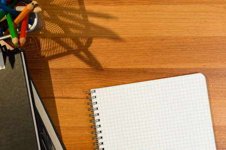 Back to school. Top view of school desk with supplies and accessories. Shadow and sun beam overlay.の写真素材