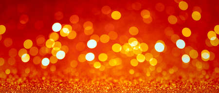 Abstract blurred background, yellow lights on red background. Golden christmas or new year bokeh.の写真素材