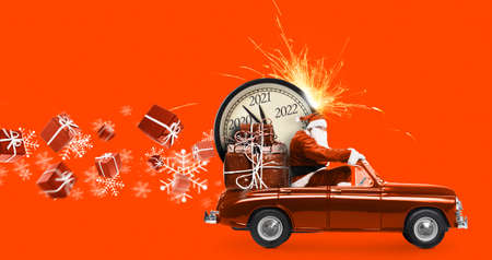 Christmas is coming. Santa Claus on toy car delivering New Year 2021 gifts and countdown clock at orange background with fireworksの写真素材