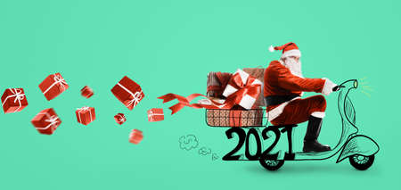 Santa Claus on scooter delivering Christmas or New Year 2021 gifts at orange backgroundの写真素材