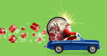 Christmas is coming. Santa Claus on toy car delivering New Year 2021 gifts and countdown clock at green background with fireworksの写真素材